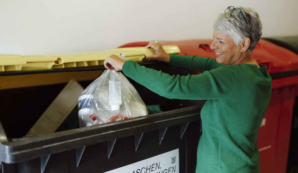Gelber Sack Entsorgung von einer Dame im Müllraum.